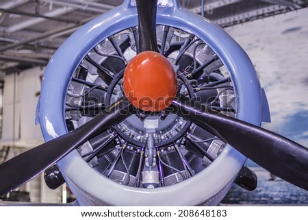 A front view of an old World War II airplane showing the engine and propeller