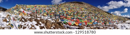 Panoramic view of Tibetan Mountains with  colorful Tibetan prayer flags.  View at the top of a mountain pass located i Tibet. The flags are symbols of happiness, longevity and luck.