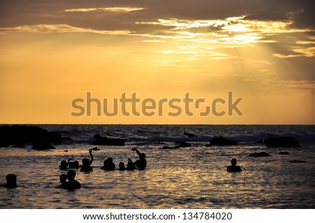 Caribbean sea at sunset with people silhouettes in the lagoon, Cuba