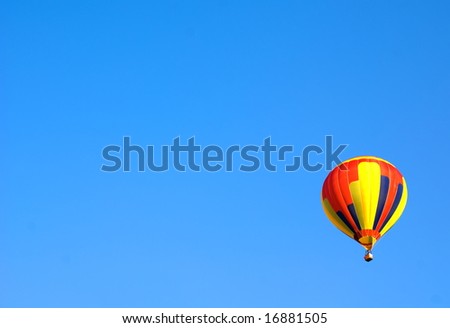 Coloured Hot Air Balloon on solid blue sky background