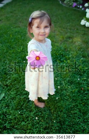 Little girl with flower. Shallow depth of field - focus on flower.