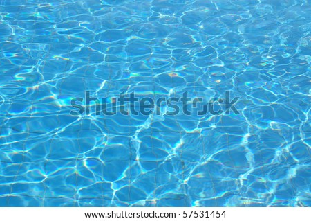 Sun reflections in swimming pool water from above.