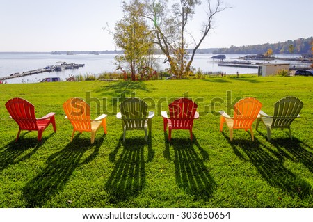 Row of lawn chairs on a green grass background in summer time. Ontario, Canada