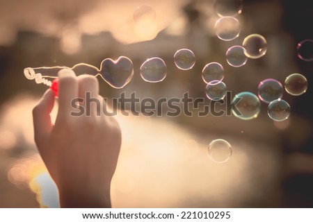 My Heart Bubbles at the sky, sunset,Love in the summer sun with bubble blower,romantic inflating colorful soap bubbles in park