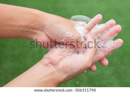 Washing of hands with soap under the running water.