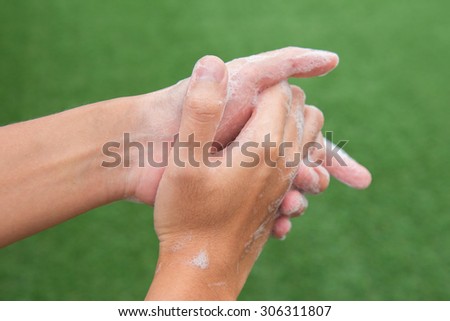 Washing of hands with soap under the running water.