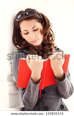 Image of young beautiful woman reading a book