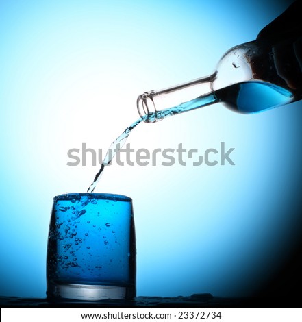 Water pouring in the glass in sapphire blue light