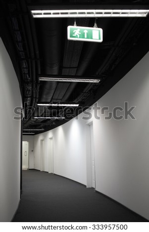 Corridor of business building with black ceiling. Turn left