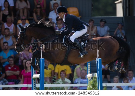 RIGA, LATVIA - JULY 27: Zigmantas Sarka  with horse Aster jumps over obstacle jumps over obstacle at World Cup qualifying round CSI2*-W/CSIYH1* RIGA-2014 on JULY 27, 2014 in RIGA