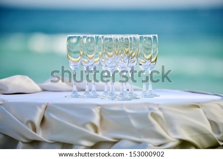 crystal glasses of champagne on the wedding Reception table  with the sea background