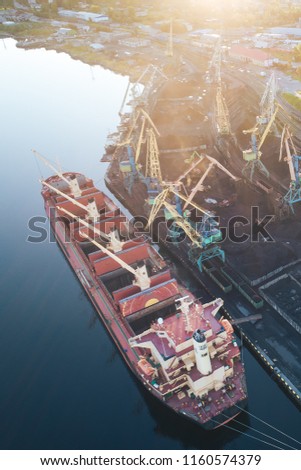 The Cargo Ship is in the Port Pier at the Loading of Coal at Sunset. Aerial View from Drone. Location Kandalaksha Town, Cola Peninsula, Russia