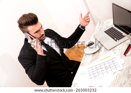 Businessman checking appointments in the calendar at the office and talking by phone