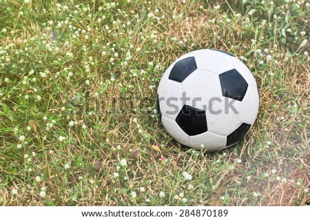 Old used football or old soccer ball on the ground