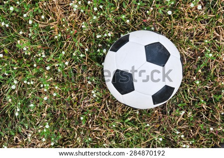 Old used football or old soccer ball on the ground