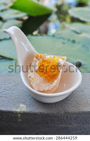 a pancake interleaved with prawns, bean sprouts, and bean curd,kind of Thai sweetmeat on  spoon