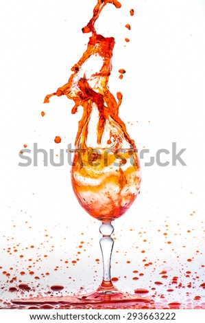 Glass of orange fresh water, Water flows into the glass make splash isolated on a white background, water drop splash on white background