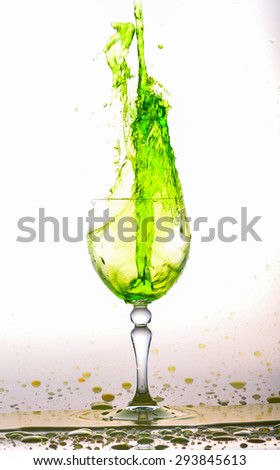 Glass of green fresh water, Water flows into the glass make splash isolated on a white background, water drop splash on white background
