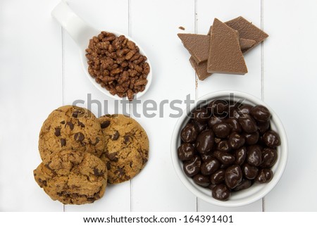 top view of chocolate crispy rice, pieces of chocolate, chocolate raisins and chocolate cookies