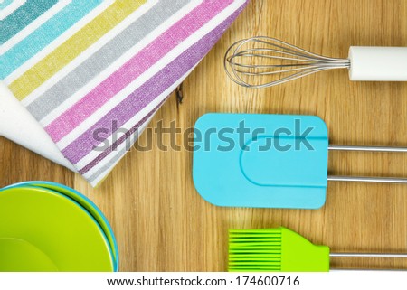 top-view of colorful striped tea towel, bowls, whisk, pastry brush