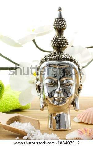 buddha composition with orchid, shells and bath products on wooden surface isolated