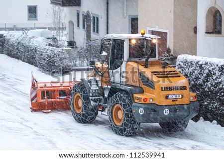 INNSBRUCK; AUSTRIA - JAN 24: Snow removal vehicle removing snow after blizzard which caused several damages on the streets of Innsbruck in Tirol, Austria on January 24, 2012.