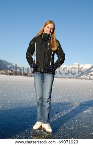 Young woman ice skating on frozen lake on a sunny day