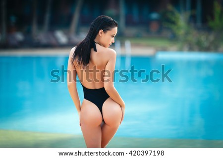 Gorgeous young woman posing in bikini near pool
