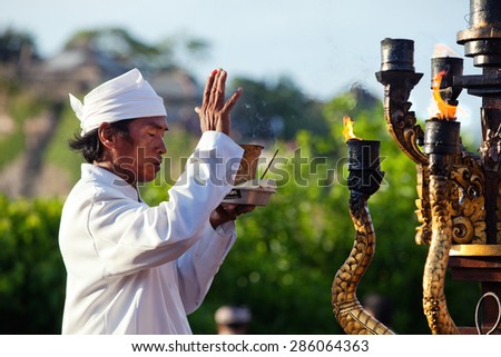 ULUWATU, BALI - CIRCA January 2011 - A temple priest gives offerings and prayers  before a traditional Fire Dance ceremony at the Uluwatu Temple. The ancient Hindu temple features ocean cliff views.