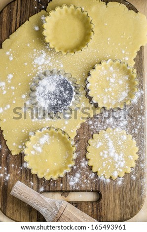 Cookie dough and molds for them on a wooden board
