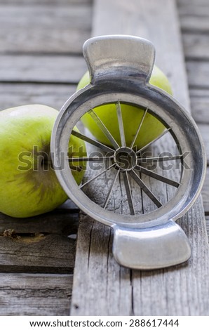 Old apple knife with two apples in the back, on a old wooden table.