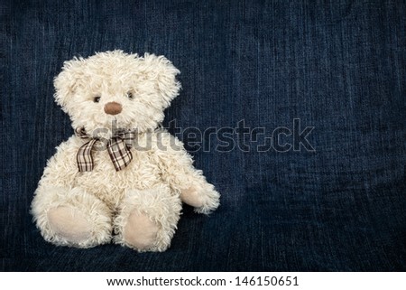 Soft Teddy bear toy on a jeans backdrop
