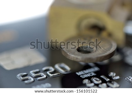macro shot of an old credit card with pad lock and key