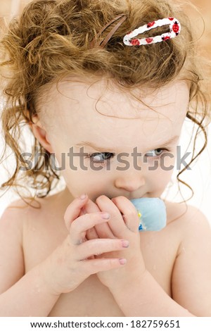Little girl playing with soap in the bath
