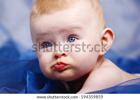 Little funny baby on the blue blanket