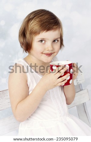 Funny little girl drinking cocoa