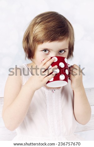 Funny little girl drinking hot chocolate