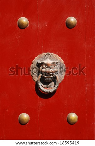 The Chinese red imperial wood door with bronze lion head and round nail head.