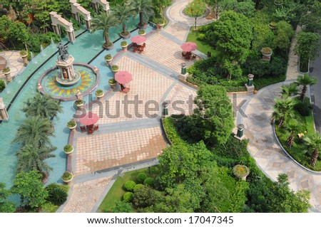 The beautiful garden with fountain,footpath,trees,bush and meadow inside a luxury apartment block.