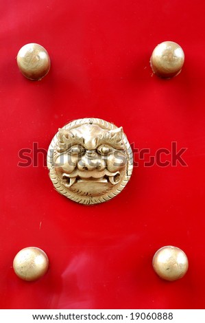 The chinese bronze lion head and nail head  red wood door.