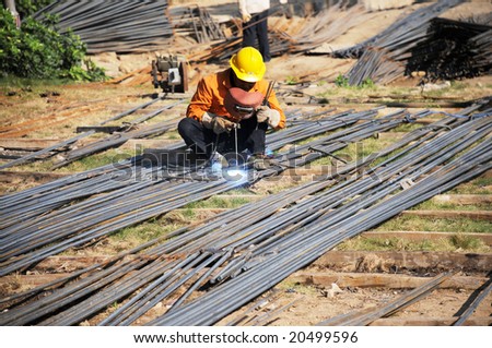 A Chinese welder works in the construction site.