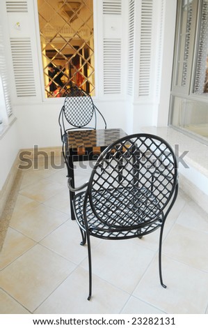 The iron chairs and tea table in the roofed balcony.
