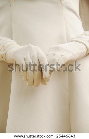 The young woman\'s hands in white gloves in the white robe in wedding ceremony.