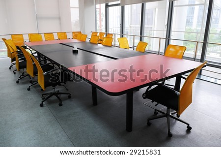 The company meeting room with big wood table and chairs.