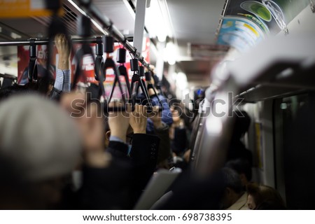 Crowded commuter train in Japan at rush hour in the evening.