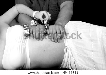 Pregnant woman with father and name blocks in black and white