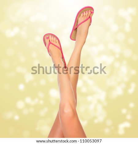 Female legs with pink flip-flops, blurred lights on background