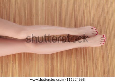 Long female legs on wooden floor