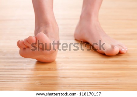 Healthy female feet on wooden floor
