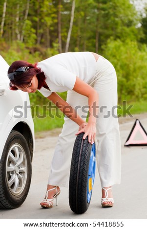 Woman trying to change a wheel